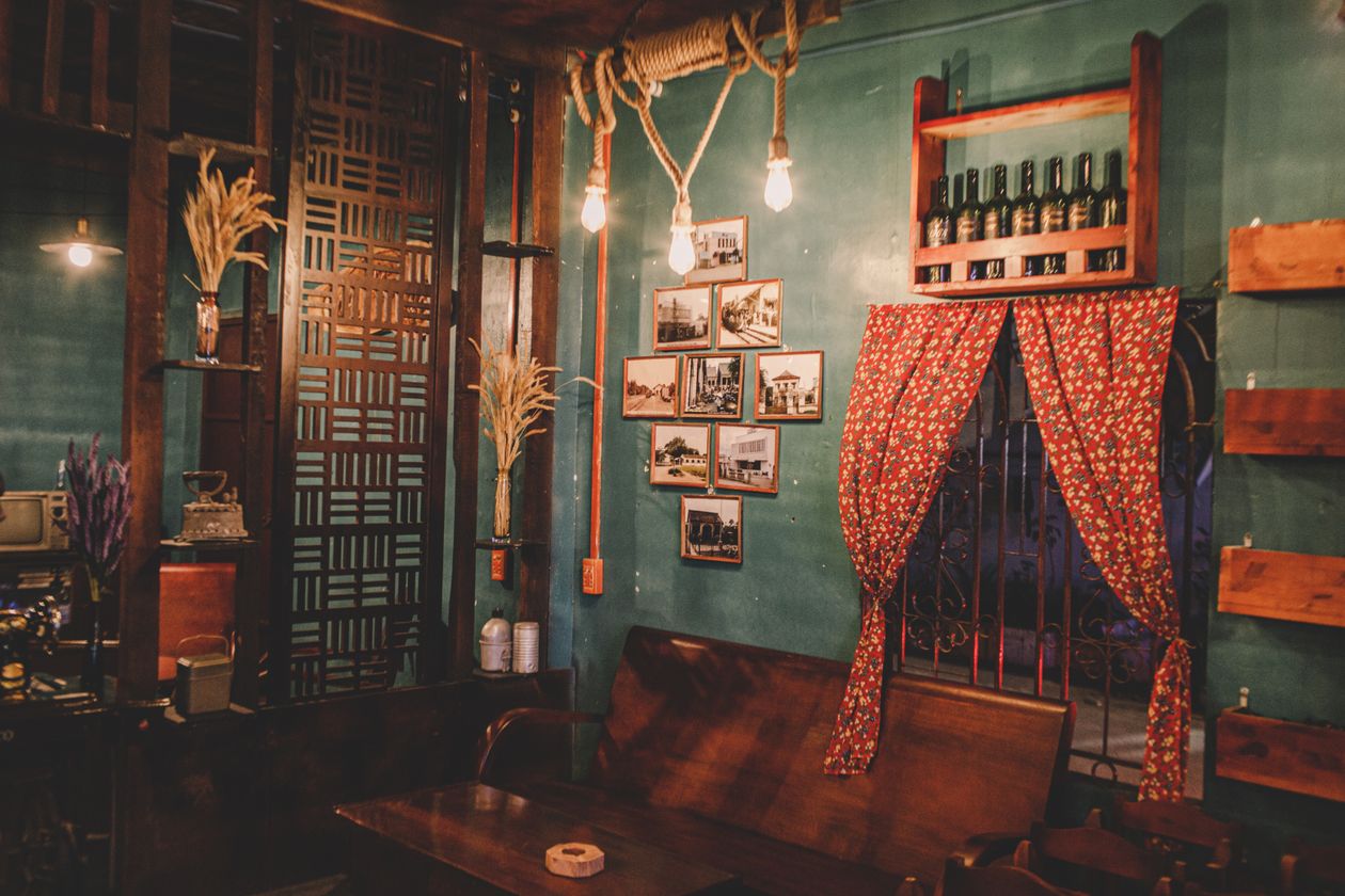 Warm vintage cafe interior with a wooden bench and framed photos