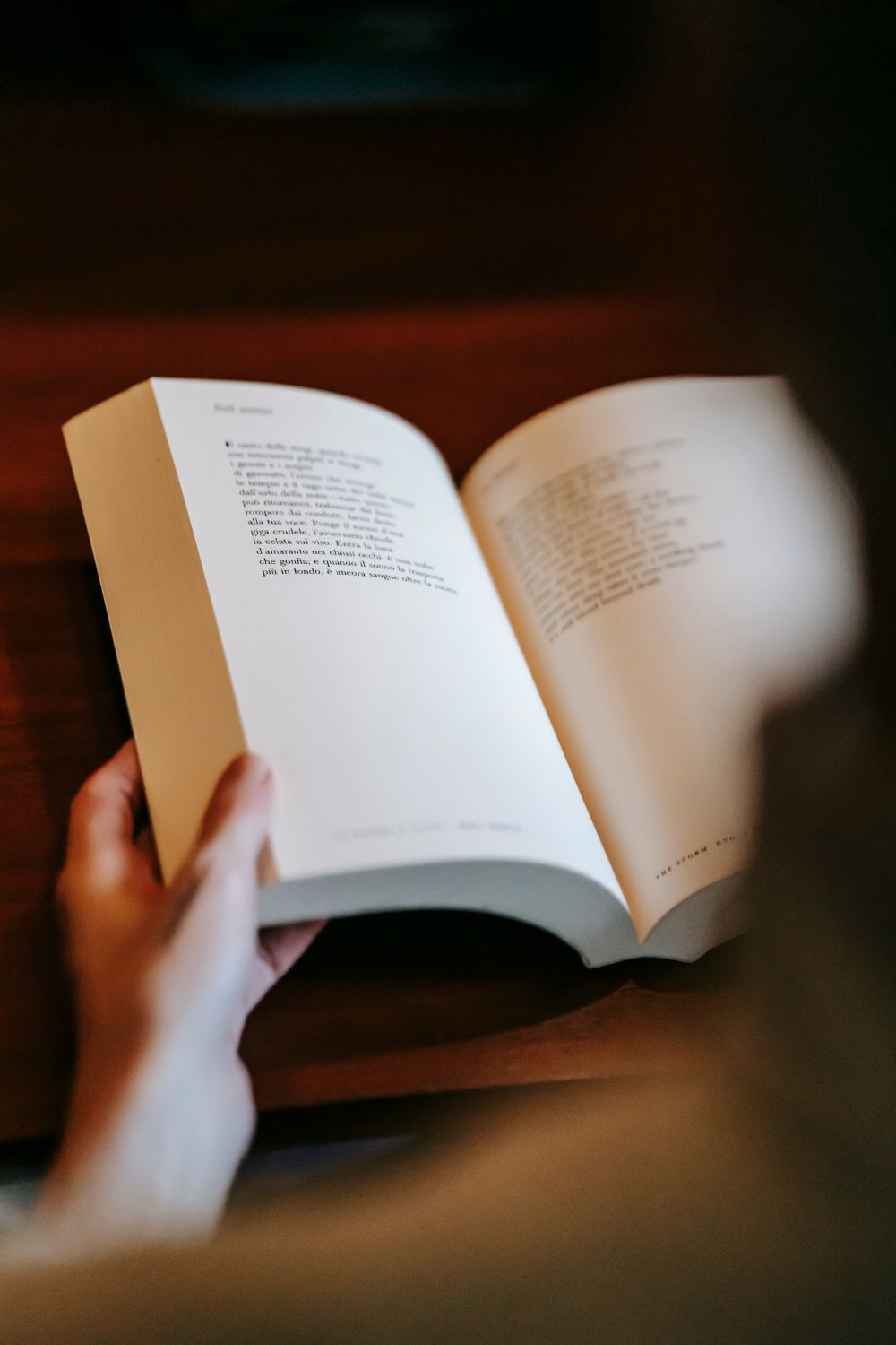Close-up of hands turning the page of an open book